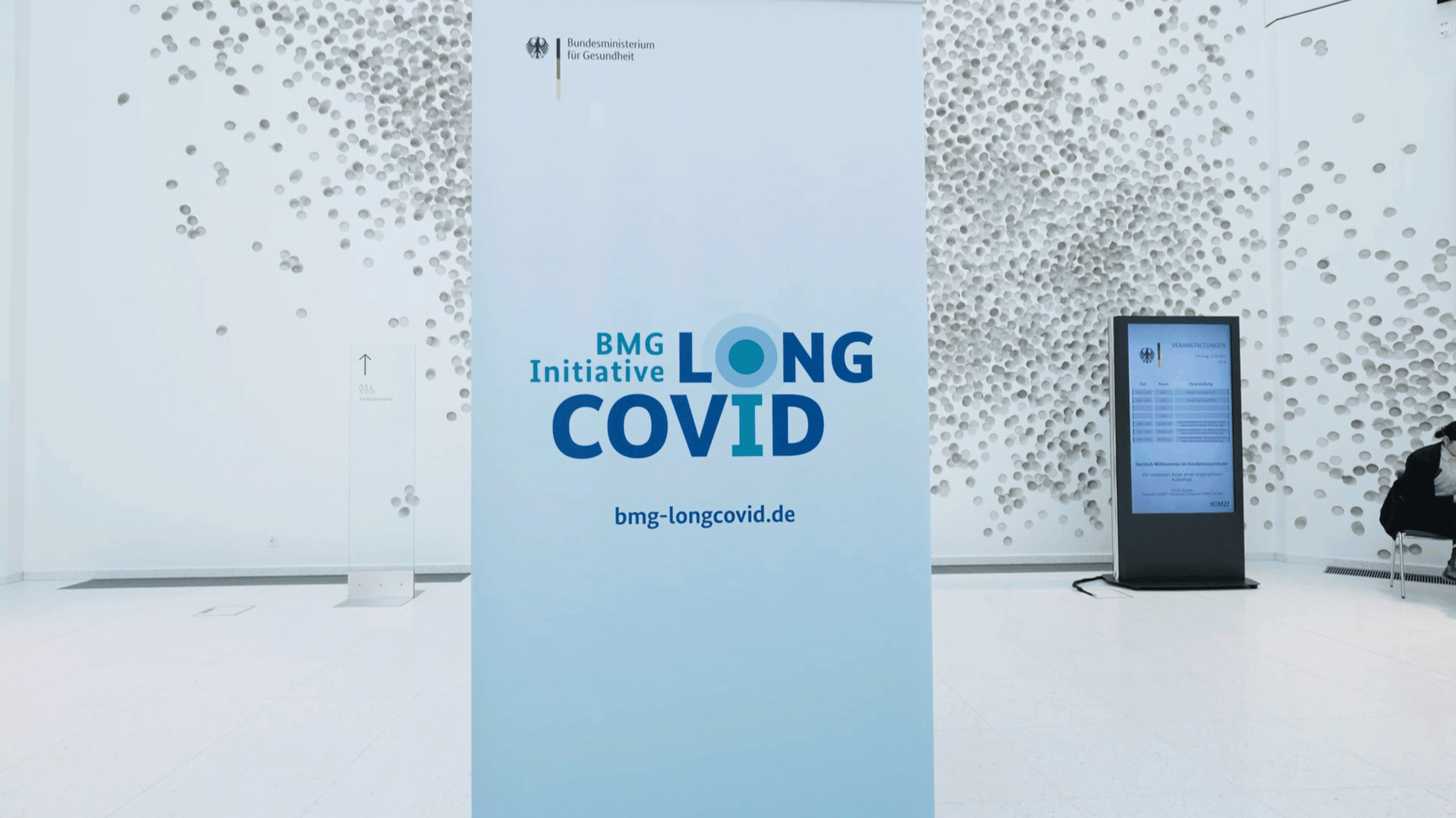 Ein Plakat zeigt das Logo der BMG Initiative Long COVID