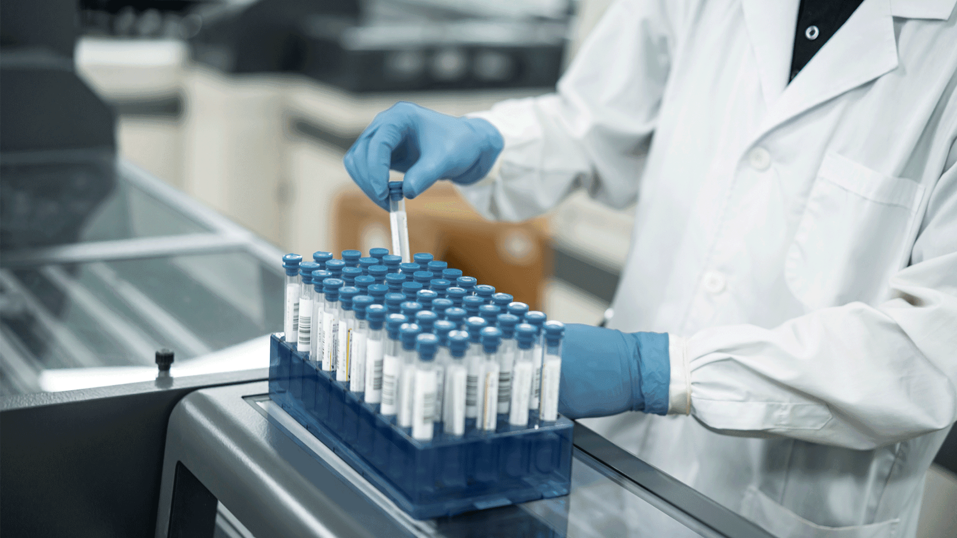 Illustration: Hand of a person wearing a gown and protective glove while working with ampoules